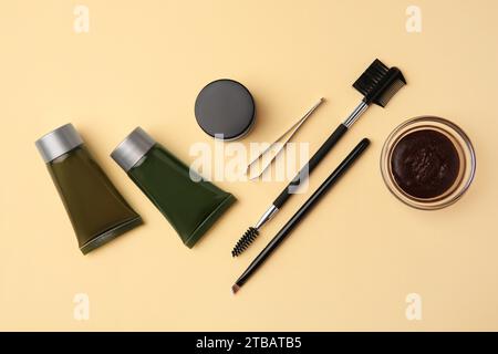 Flat lay composition with eyebrow henna and tools on beige background Stock Photo
