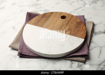 Serving board and napkins on white marble table, closeup Stock Photo