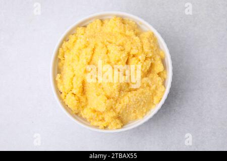 Tasty cornmeal in bowl on light gray table, top view Stock Photo