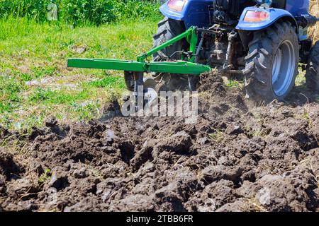 Farmer in tractor prepares ground for sowing for spring season Stock Photo