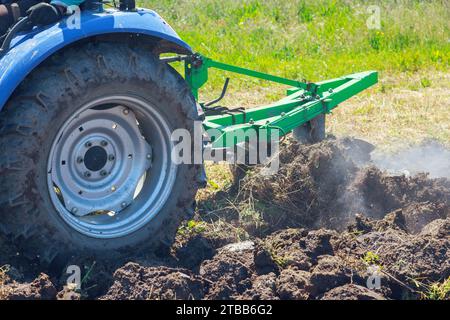 Tractor ploughs land in autumn, preparing it for spring planting operation Stock Photo