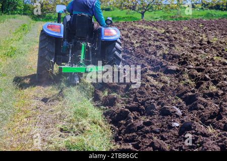 In autumn, tractor plows land, preparing it for spring work Stock Photo