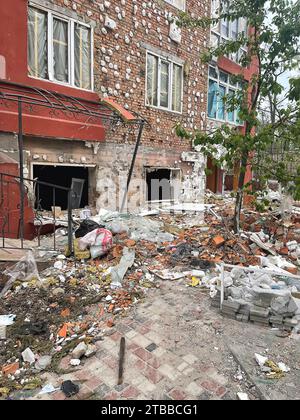 Irpen, Ukraine. May 07. 2022 Mountains of construction debris on the sidewalk under the house where the projectile hit, broken bricks and windows Stock Photo