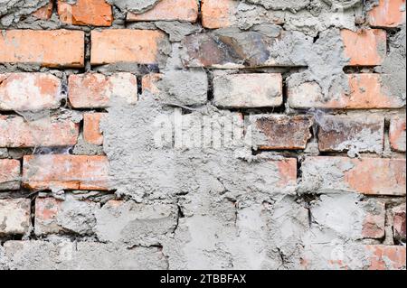 The background of the old wall is made of brown bricks, laid out from a cement sand mortar Stock Photo