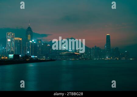 Pink and orange sky over Hong Kong Island with smooth sea from long exposure. Stock Photo