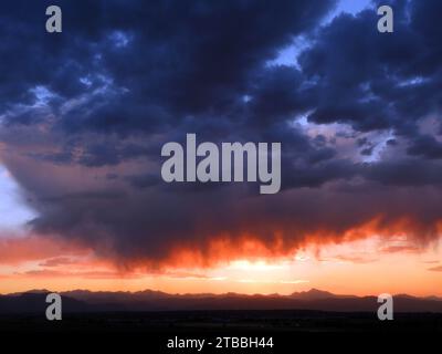 Dramatic sunset and Virga clouds over the front range of the Rocky Mountains, as seen from Broomfield, Colorado Stock Photo