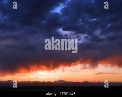 Dramatic sunset and Virga clouds over the front range of the Rocky Mountains, as seen from Broomfield, Colorado Stock Photo