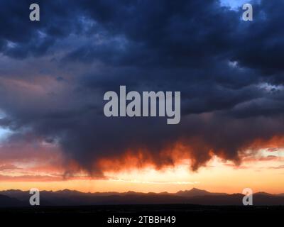 Dramatic sunset and Virga clouds over the front range of the Rocky Mountains, as seen from Broomfield, Colorado Stock Photo