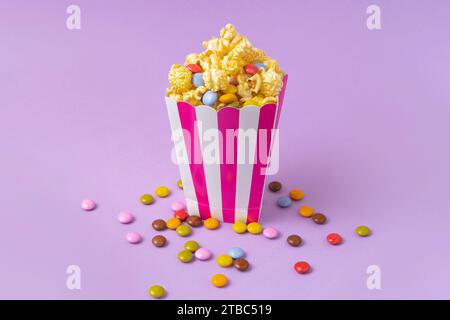 sweet popcorn with dragee on purple background Stock Photo