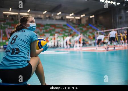 LUBIN, POLAND - OCTOBER 04, 2021: Men's Volleyball Polish PlusLiga match Cuprum Lubin VS Skra Belchatow 1:3. Girl passing balls and players in the bac Stock Photo