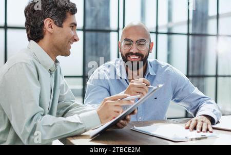 Startup partners discussing project at laptop, watching video presentation Stock Photo