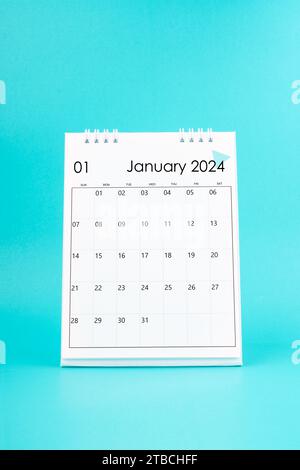 Desk calendar for January 2024 and white paper clip on a light blue ...