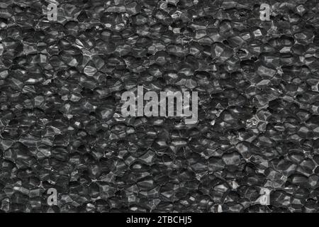 Black Expanded polyethylene foam sample background. EPE beads packing material with macro detail cells, textures and one solid color. Stock Photo