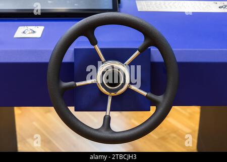 Marine navigation simulation system, ship control panel with steering wheel and electronic  equipment on the captain bridge, close up front view Stock Photo