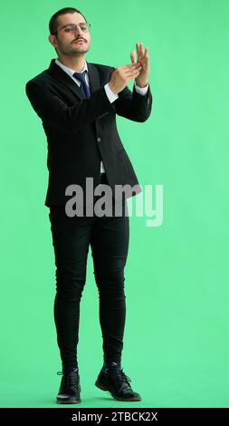 young man in full growth. isolated on green background shows timeout Stock Photo