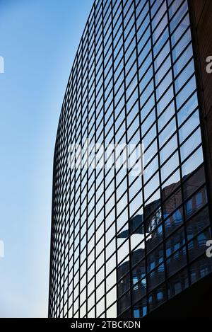 Glazed modern office facade against a clear sky reflecting on the glazed building exterior. Fine business or headquarter contemporary facade in Berlin Stock Photo