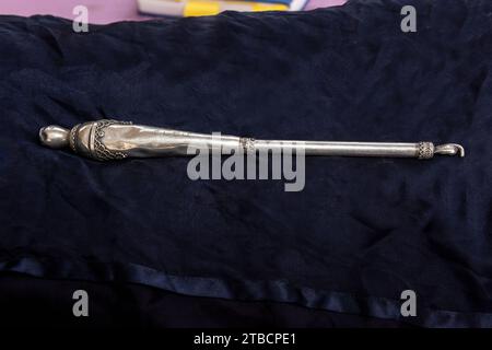 A silver pointer called a yad in Hebrew is used to guide the Torah scroll reader through the text during Jewish prayer services. Stock Photo