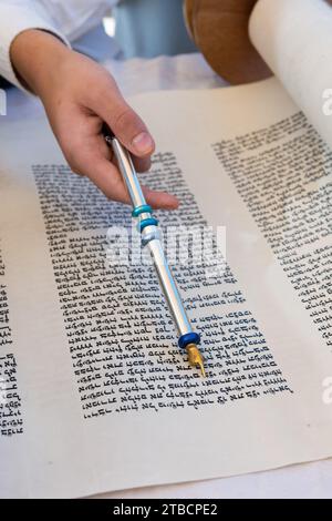 A boy reading from the Torah during his bar mitzvah celebration in Israel, holds a silver yad, a pointer used to guide the reader through the ancient Stock Photo