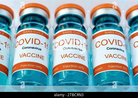 Row Bottles with covid-19 vaccine in plastic box. Medicine and corona virus infection concept. Close up Stock Photo