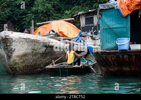 Young vietnamese girl in rowing boat near her floating home Stock Photo