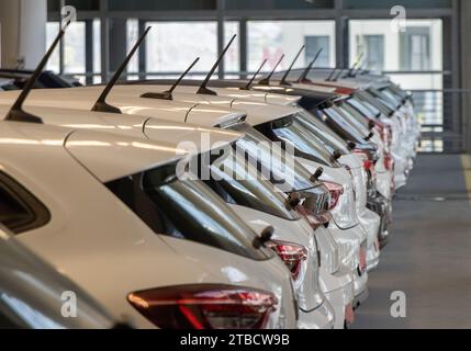 Used car sales Cars in a row Car Dealer Inventory Indoor garage Stock Photo