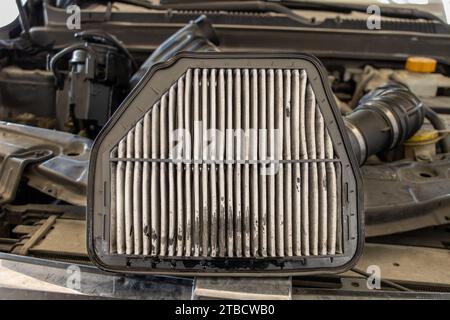 Car air filter replacement. changing a old air filter in cars engine. Mechanic replaces dirty air filter and installs new filter. Vehicle maintenance Stock Photo