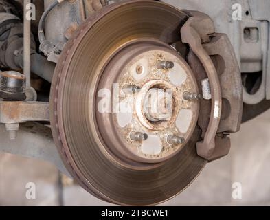 Disk brake pad and car disk brake system change service. Car disk brake pad replacement service by hand of mechanic man in car garage Stock Photo