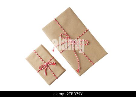 Two Christmas and New Year gift boxes wrapped in brown craft kraft paper with red and white baker's twine, ribbon bow isolated on white background Stock Photo