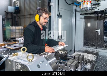 Engineer working with a milling cnc machine using safety gear Stock Photo