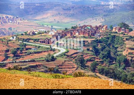 Terraced fields and two stories brick houses in Betsileo rural village in the Ambositra District, Amoron'i Mania Region, Central Madagascar, Africa Stock Photo