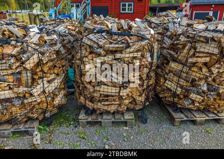 Pre-packaged birch logs, ready for sale, neatly bundled in transport sacks and arranged on pallets. Sweden. Stock Photo