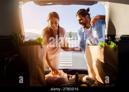 Middle eastern spouses enjoys organizing groceries in car trunk Stock Photo