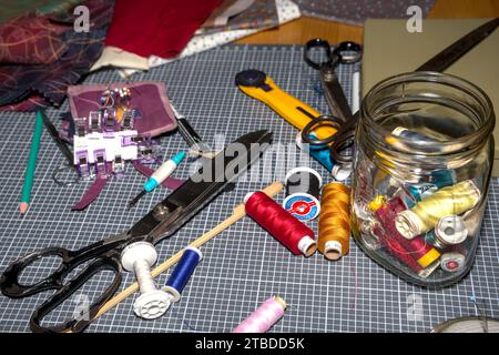 sewing table with drappery material and many equipement in disorder Stock Photo