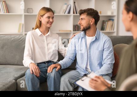 Young couple sits after productive counseling session with psychologist indoors Stock Photo