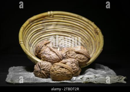 Close-up of a group of nuts in a wicker basket on a white lace doily in an old-world atmosphere Stock Photo
