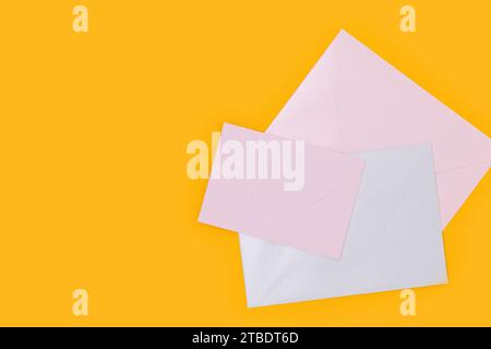 Multicolored envelopes on a yellow background. Minimal concept with place for your design. Stock Photo