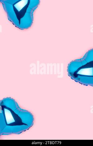 Frame made of blue foil balloons in a heart shape on a pink background. Creative composition. Stock Photo