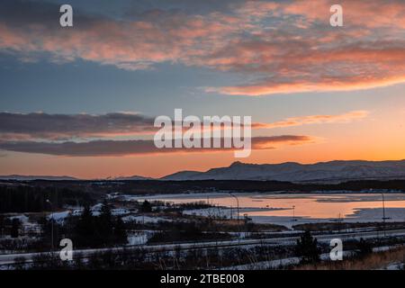 Sunset winter landscape of Reykjavik town suburbs and mountains, Iceland.  Beautiful orange clouds in th sky. Stock Photo