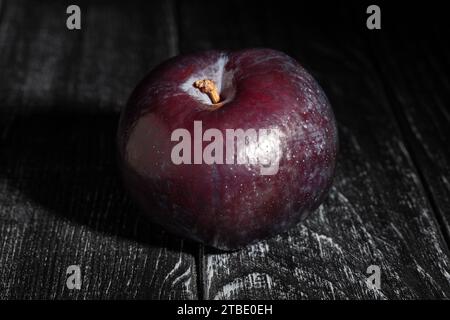 single plum on wood background Stock Photo