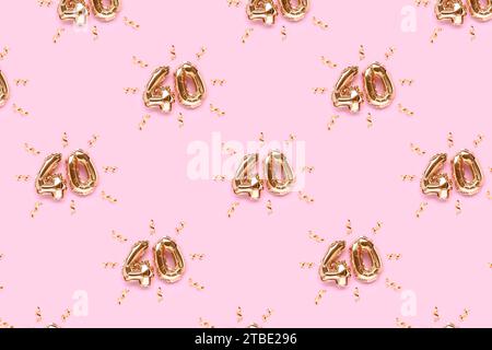 Pattern made of number 40 golden air balloons with ribbons confetti on a pink background. Creative composition. Stock Photo