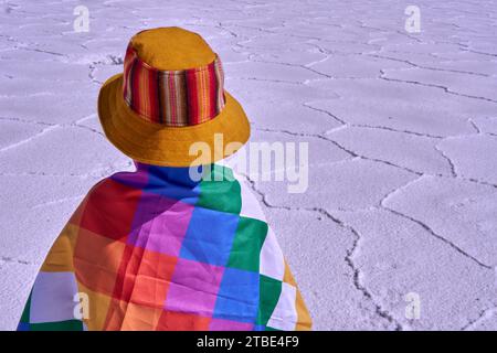 portrait of an Argentinian child belonging to the native peoples with a wiphala flag on his back in Salinas Grandes Jujuy. Salt flat in Argentina Stock Photo