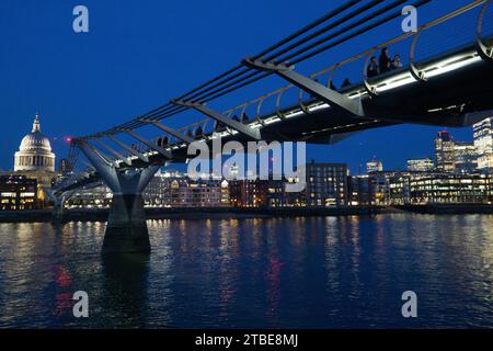 UK Weather, 6 December 2023, London: After sunset on a cold clear day -- the last before more bands of rain are expected for several days -- the lights of St Paul's Cathedral, the Millennium Bridge and the office blocks of the City of London are reflected in the calm waters of the river Thames. Credit: Anna Watson/Alamy Live News Stock Photo