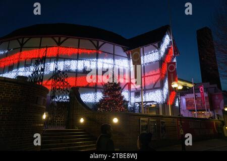 UK weather, 6 December, London: At dusk on a cold but clear day, Shakespeare's Globe theatre puts on a display of changing fairy lights, with the tower of Tate Modern seen in the background against a dusk sky. Credit: Anna Watson/Alamy Live News Stock Photo