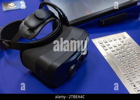 VR headset lays on the desk near industrial built-in keyboard, close up photo with selective focus Stock Photo