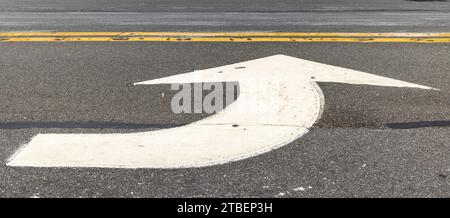 large white arrow painted on an east hampton street Stock Photo