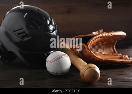 Baseball glove, bat, ball and batting helmet on wooden table Stock Photo