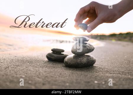 Wellness retreat. Woman stacking pebble stones on sandy beach, closeup Stock Photo