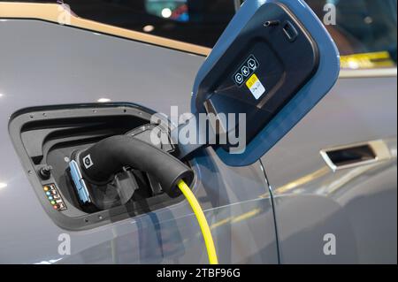 Power cable pump plug in charging power to electric vehicle EV car Stock Photo