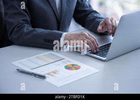 Businessman working with laptop computer while reviewing business performance and return on investment Stock Photo
