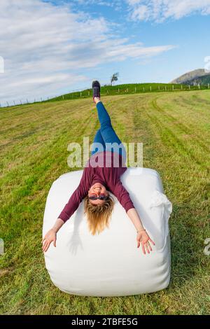 Beautiful 40-Year-Old Woman Posing on a Packed Hay Stack in a Serene Field Setting Stock Photo